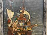 une vieille image représentant un bateau pirate, dans un cadre en bois