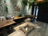 une pièce avec une table, des chaises et une plante accrochée au mur