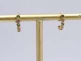 a close up of a pair of earrings on a gold stand
