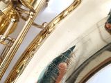 a close up of a saxophone with a person ' s hand on it