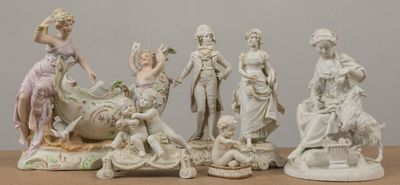cinq figurines assises sur une table, dont l'une tient une fleur