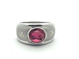 Gros plan sur une bague ornée d'une pierre rose