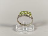 a close up of a ring with three green stones on it