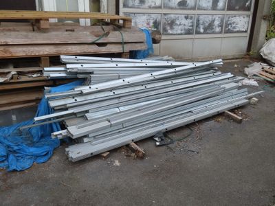 many pieces of metal on the ground outside of a building