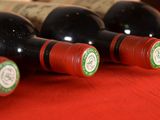 several bottles of wine are lined up on a red table