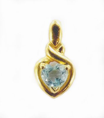 un gros plan sur un pendentif en forme de cœur orné d'une topaze bleue