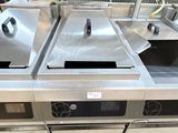 plusieurs éviers en acier inoxydable dans une cuisine professionnelle dotée d'un sol carrelé