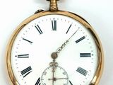 a gold pocket watch with roman numerals on the face