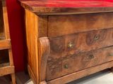 a wooden chest of drawers in a room with a red wall