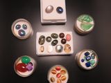de nombreuses billes de différentes couleurs dans de petits bols posés sur la table
