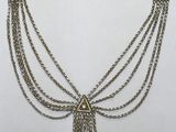 un gros plan d'un collier composé de chaînes et d'un pompon