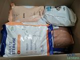 many bags of cat food in a cardboard box
