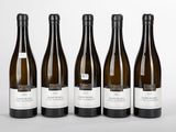 six bottles of wine are lined up on a white surface