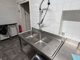 une cuisine avec un évier, une cuisinière et un lave-vaisselle