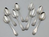 six silver spoons are arranged in a circle on a table