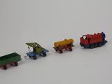 three toy trains that are sitting on a white surface