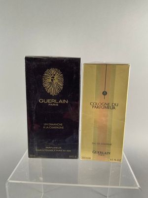 two boxes of perfume sitting on top of a clear shelf