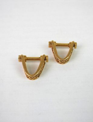 une paire de boucles d'oreilles dorées ornées d'un petit motif triangulaire