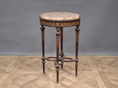 une petite table avec un plateau en marbre sur un plancher en bois