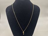 a gold necklace on a mannequin neck with a white background