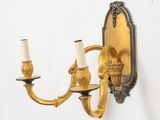 a wall mounted candle holder with two candles on it