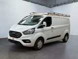 La camionnette blanche est garée dans une grande pièce aux murs blancs.