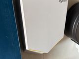 a toilet in a bathroom with a paper dispenser next to it