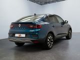 the rear end of a blue car parked in a garage