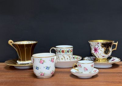 five cups and saucers sitting on a wooden table