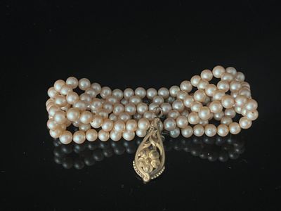 pearl necklace with a gold clasp and a large pearl bead