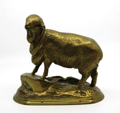 statue en bronze représentant un mouton debout sur un rocher, sur fond blanc
