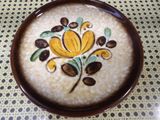 a brown bowl with a yellow flower painted on it