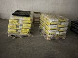 deux piles de palettes contenant un matériau jaune dans un entrepôt