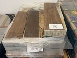 plusieurs piles de planches de bois empilées sur des palettes dans un entrepôt