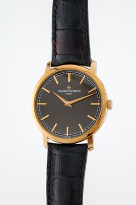 an image of a black and gold wrist watch with a black dial