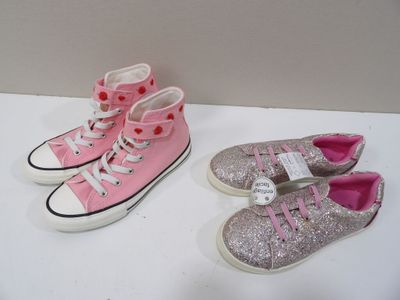 Deux paires de Converse roses et argentées sont posées sur une surface blanche.