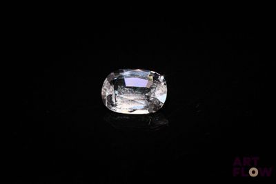 un diamant blanc sur une surface noire dans l'obscurité