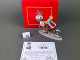 a figurine of a man riding a bike next to a red box