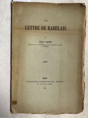 un vieux livre posé sur une table à côté d'un mur blanc