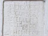 une plaque apposée sur le mur d'un immeuble, sur laquelle figurent des inscriptions