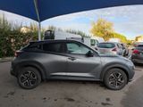 a silver suv parked under a blue umbrella