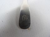 a silver spoon with a silver handle on a white surface