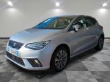 une voiture argentée est garée sur le sol à carreaux d'un garage