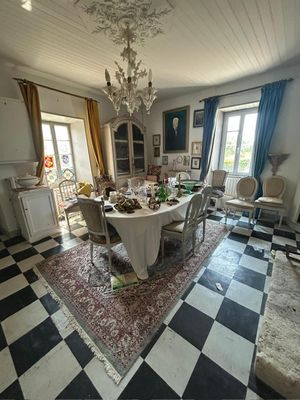 une salle à manger avec un sol en damier et un lustre
