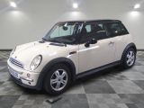 une photo d'une Mini Cooper blanche garée sur un sol à damier