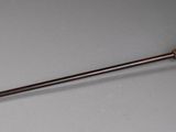 an old wooden stick with a wooden handle on a gray surface