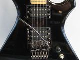 an image of a black electric guitar sitting on top of a white surface