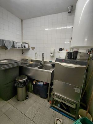 une cuisine équipée d'un évier, d'une cuisinière et d'une poubelle