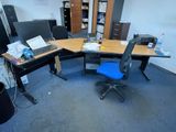 a desk with a laptop and a chair in the corner