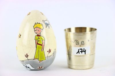 un œuf sur lequel est dessiné un garçon, à côté d'une tasse